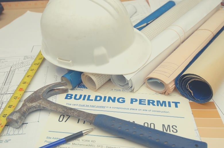 A building permit along with a hard hat. Does your garage need a building permit. Yes, otherwise the government can impose penalties and fines.