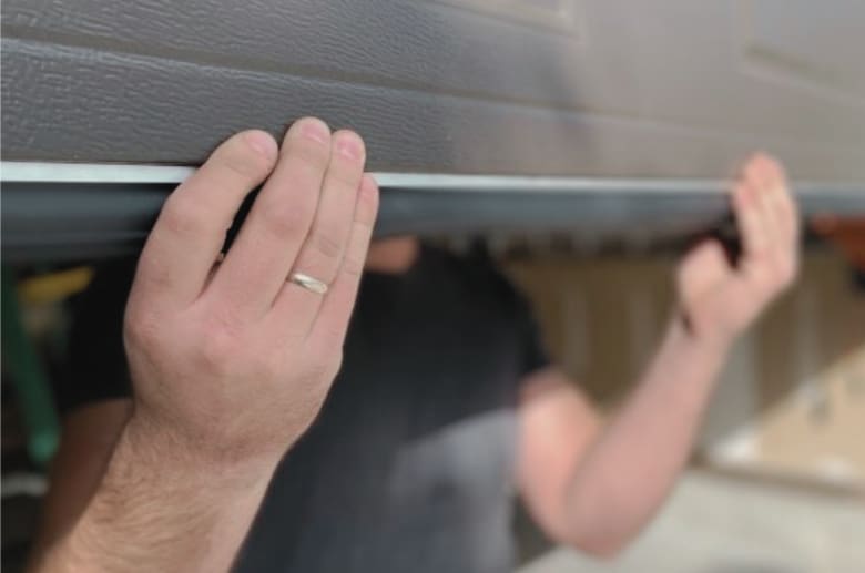 Lift the door with both hands when the garage door springs are broken.