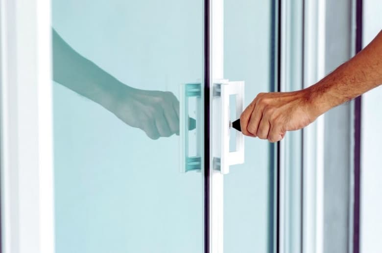 Someone is unlocking a sliding glass door. It is an alternative entry when you are locked out of garage door.
