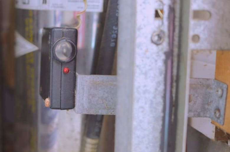 A garage door sensor. A garage door clicking can be caused by an obstruction on the sensor.