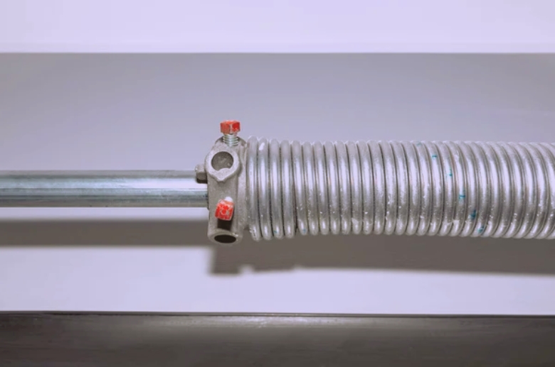 A garage door spring. A garage door clicking can be caused by damaged springs.