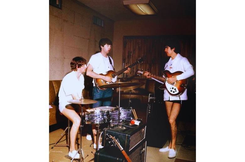 The Beatles playing inside a garage. 
