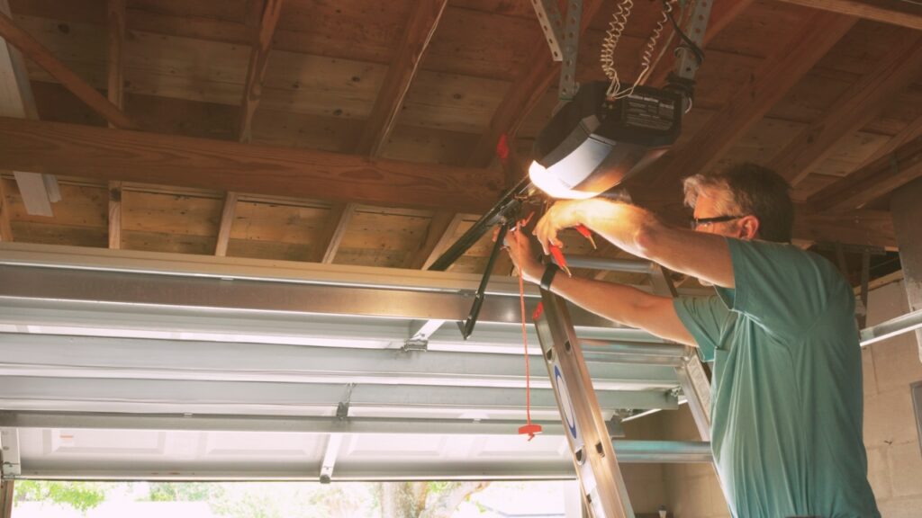 A man installing a garage door by following garage door installation instructions.
