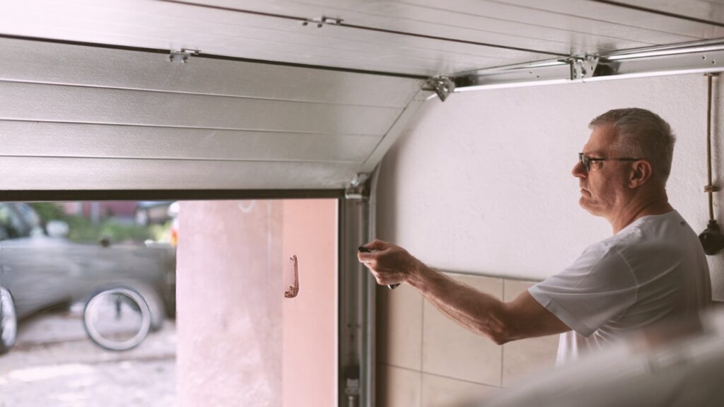 A man opening a garage door. Know how to fix issues when a garage door makes loud noise when opening.