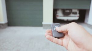 A guy opening a garage door with a remote. Fix issues when garage remotes not working.